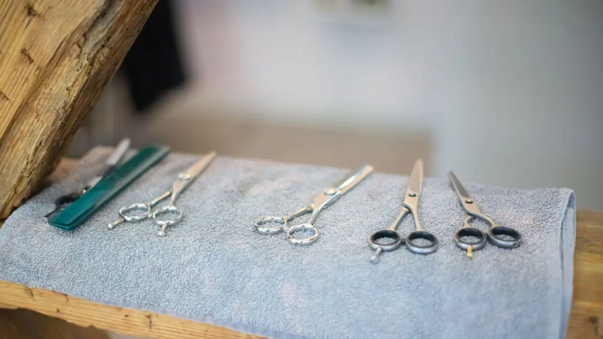 Des ciseaux et un peigne posés sur une serviette de salon de coiffure.