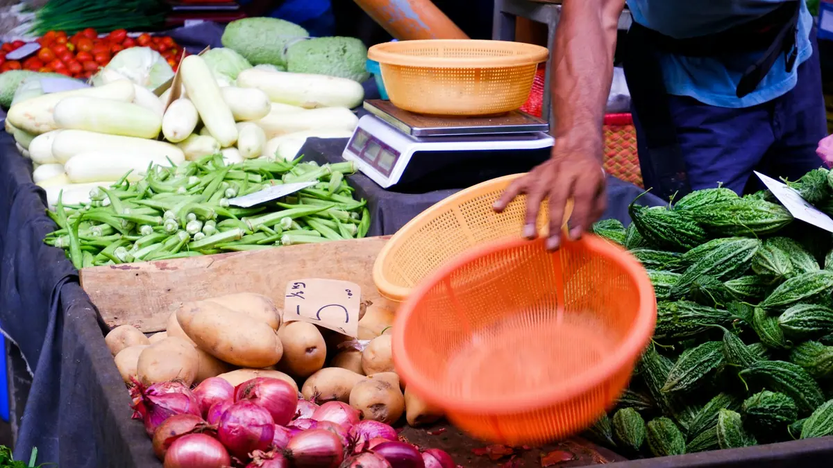 Un étal de marché présentant différents légumes frais.